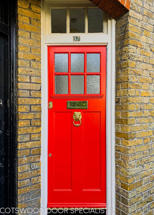 Textured glass 1920s door. 1920s door is painted bright red with brass furniture including a lion knocker. Door is fitted into a north london yellow stock home