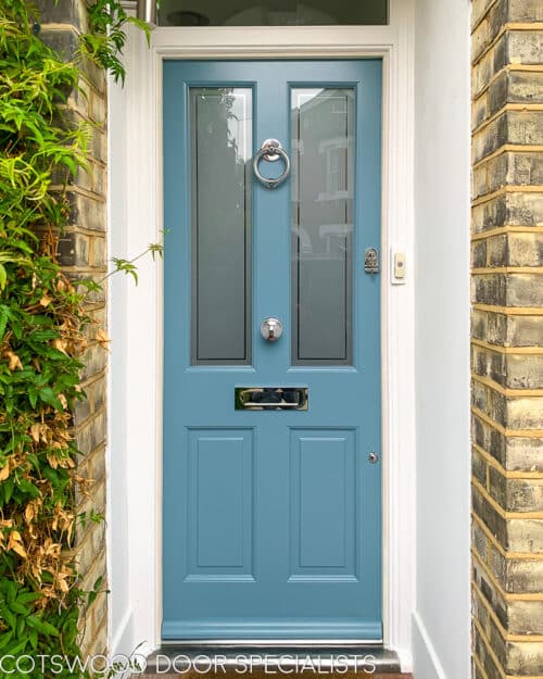 Two glass Victorian door painted light blue. Fitted with sandblasted glass with a clear inset border. Door has polished chrome door fittings including a ring knocker. Classic London terraced home