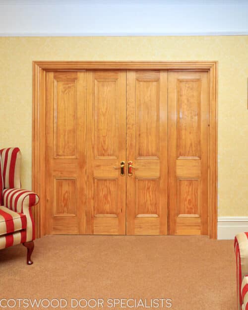 Victorian room divider. Four door room divider, 2 doors folding to each side on hinges. Door show off natural wooden grain.. Doors divide living room and dining room