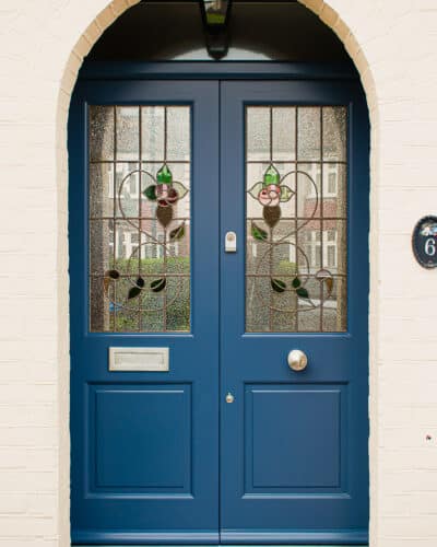 Blue 1930s double doors. Traditional 1930s double doors featuring a leaded rose stained glass. Door and frame painted blue and featuring satin chrome door furniture.