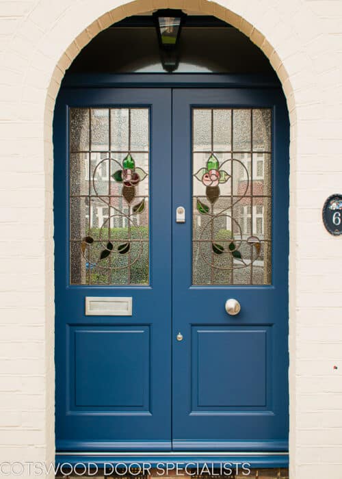 Blue 1930s double doors. Traditional 1930s double doors featuring a leaded rose stained glass. Door and frame painted blue and featuring satin chrome door furniture.