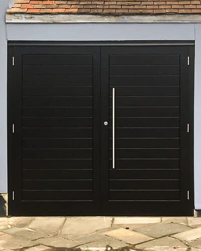 Contemporary garage doors. Door and frame painted black. Door feature horizonal boarding and large sating chrome door handles