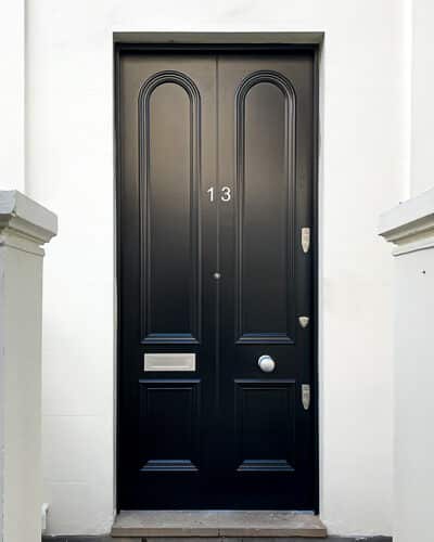Curved moulding Victorian door. Transitional front door between Georgian and Victorian period. Extra tall and wide door, made to look like a pair with a beading to centre. All painted satin black with satin chrome hardware. Copy of original door and mouldings.