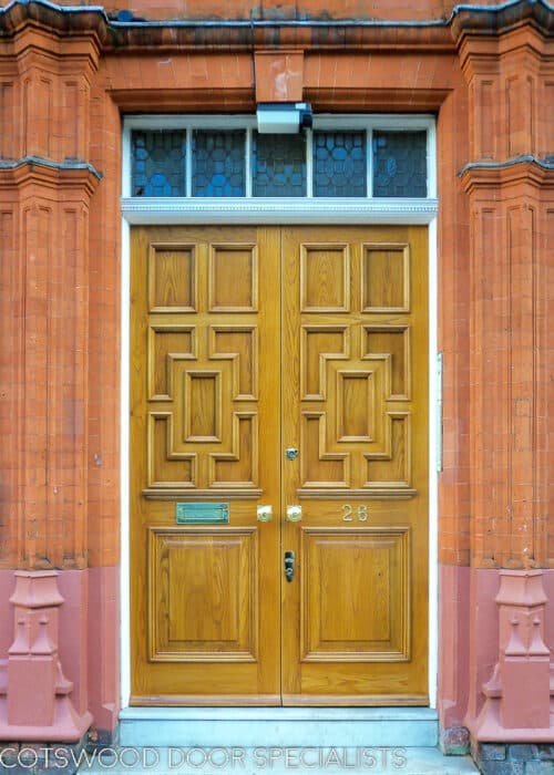 Decorative Georgian double doors. Doors made to replicate original listed doors on London apartment block. Doors have multiple panel styles and intricate shapes. Fitted with brass door furniture. Doors natural wooden finish