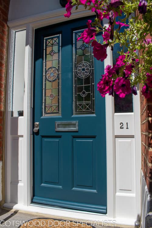 Blue Victorian front door and large door frame fitted into a Victorian Mansion. Impressive red brick and corbelled surround. Door has stained glass with different textures and colours. Blue door and white door frame, satin chrome locks and hardware