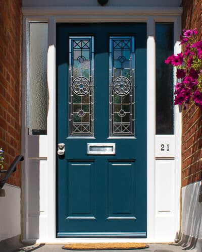 Blue Victorian front door and large door frame fitted into a Victorian Mansion. Impressive red brick and corbelled surround. Door has stained glass with different textures and colours. Blue door and white door frame, satin chrome locks and hardware