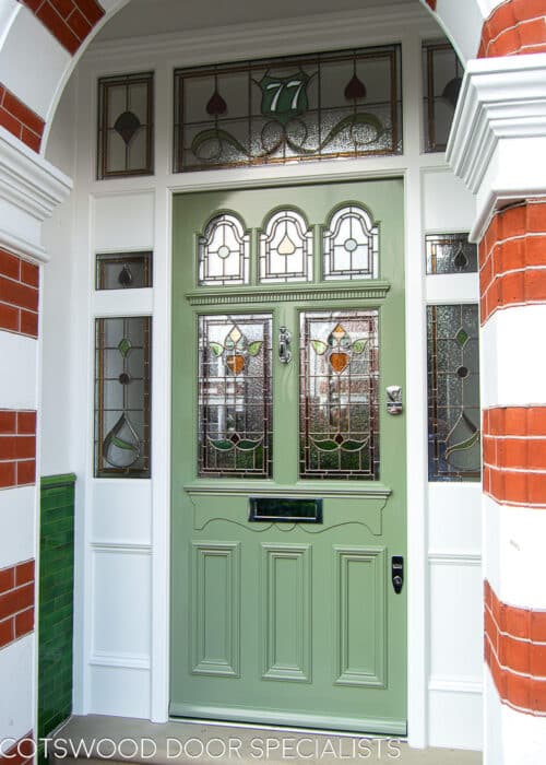 Green Edwardian front door. Ornate Edwardian front door with 5 glazed panels. Decorative dental block mouldings and also apron of which letterplate is fitted to. Glossy green paint with white door frame. Impressive front entrance with large apreture surrounded by decorative brick arch. Door frame has double sidelights. Full stained glass design to all galzing including the number above the door. Polished chrome door hardware