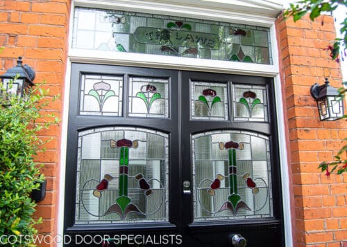 Art Nouveau Double doors. Doors are painted black with chrome door fittings. Recreation of orginal edwardian design- highly decorative. Stained glass with different glass textures incluing reeded glass. Black doors, white frame red brickwork