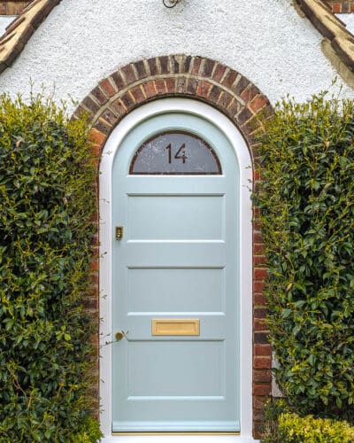 Arched 1920's front door and new frame fitted into a London home. Door and frame are both made of Accoya wood and painted in Teknos paint. The door has a sandblasted glass panel with a clear line and number detail in relief. Brass door furniture fitted. The arched frame matches the brickwork and is a true semi circle. Door made to closely match orginal simple 1920s doors locally
