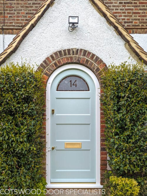 Arched 1920's front door and new frame fitted into a London home. Door and frame are both made of Accoya wood and painted in Teknos paint. The door has a sandblasted glass panel with a clear line and number detail in relief. Brass door furniture fitted. The arched frame matches the brickwork and is a true semi circle. Door made to closely match orginal simple 1920s doors locally